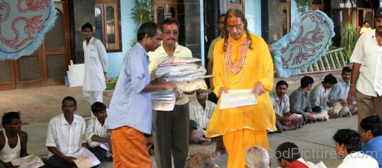 Kripalu Maharaj Ji Handing Out Sheets